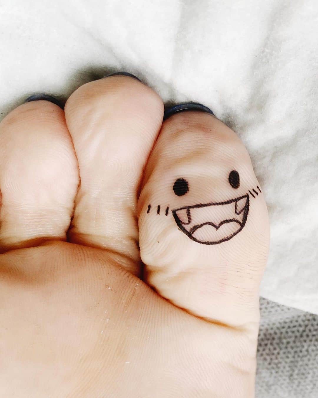 Tatuaje en el dedo del pie, cara sonriente 