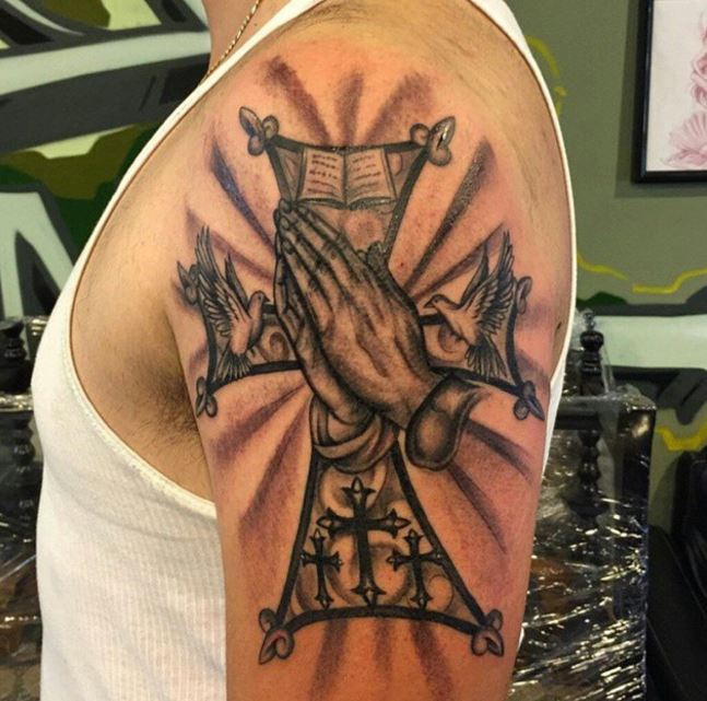 Tatuaje en el antebrazo, cruz de la Biblia y oración de la mano