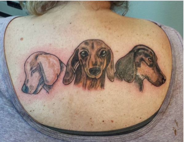 Diseño de tatuajes de raza de perro en la parte trasera de las mujeres