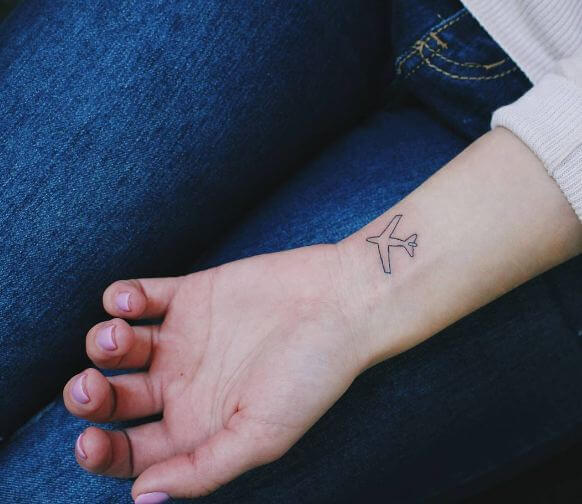 Pequeños tatuajes de aviones en la muñeca