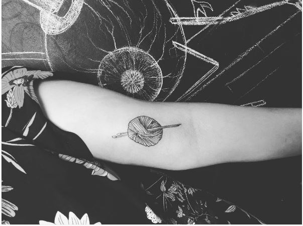 Diseño de tatuajes de tejer en bíceps de mujeres