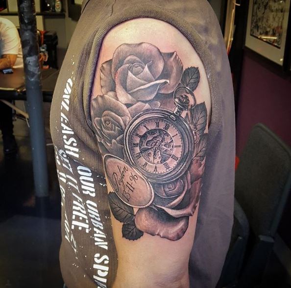Reloj reloj y diseño de tatuajes florales en bíceps
