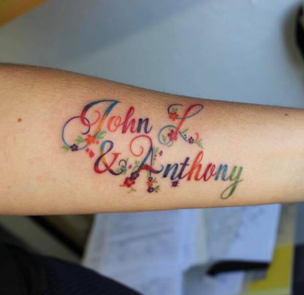 Diseño colorido del tatuaje del nombre en el antebrazo