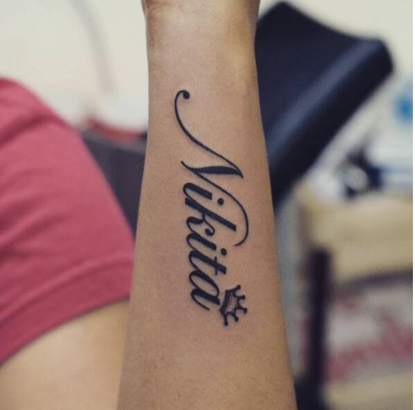 Diseño de tatuaje de nombre Nikita en el antebrazo para niñas