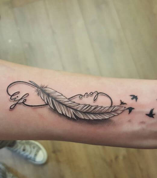 Pequeño tatuaje de pluma e infinito en el antebrazo