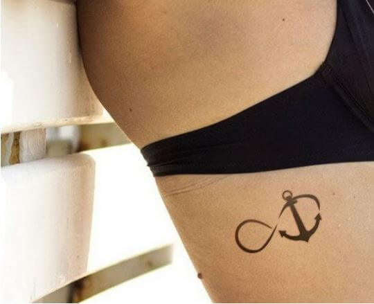 Mujer con símbolo de infinito y tatuaje de ancla