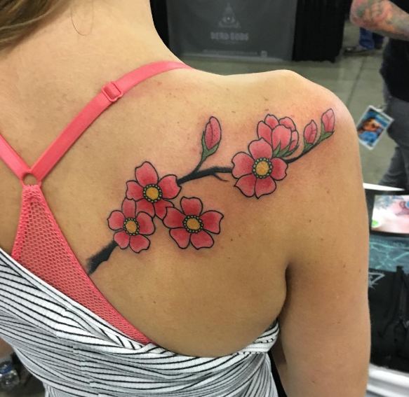 Pequeños tatuajes femeninos de flores en la espalda