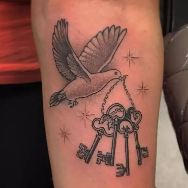 Tatuajes de paloma y llaves en el antebrazo