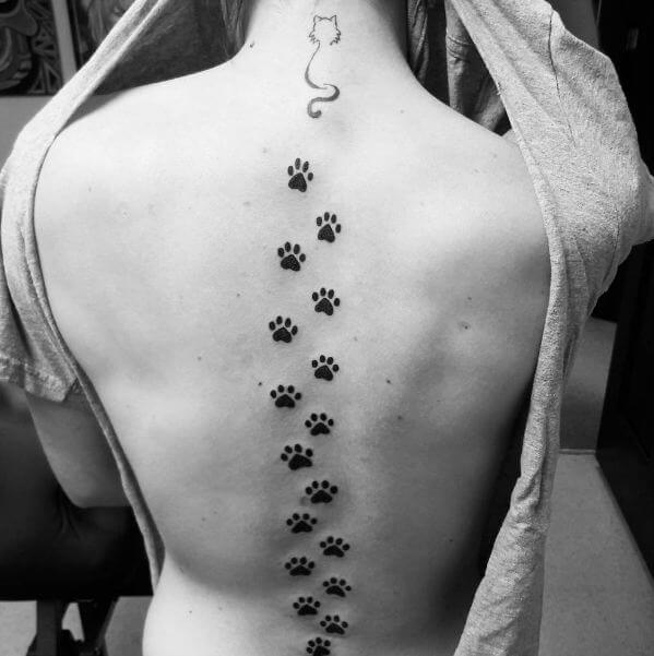 Tatuajes de gatos con patas en la columna vertebral para niñas
