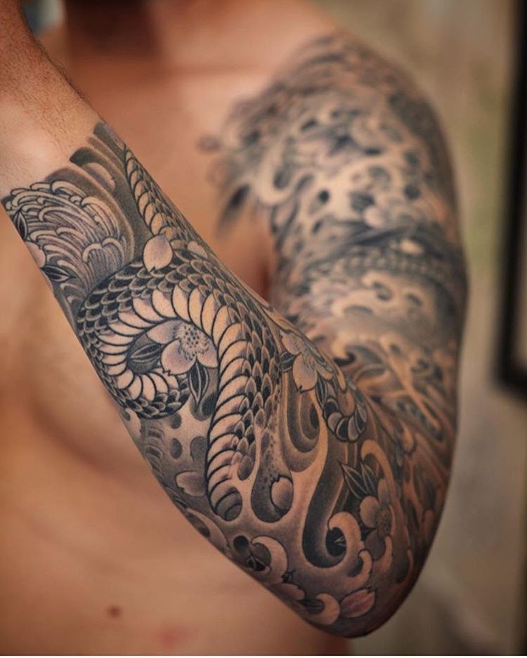 Tatuaje en el brazo, mitad negro mitad hombre japonés