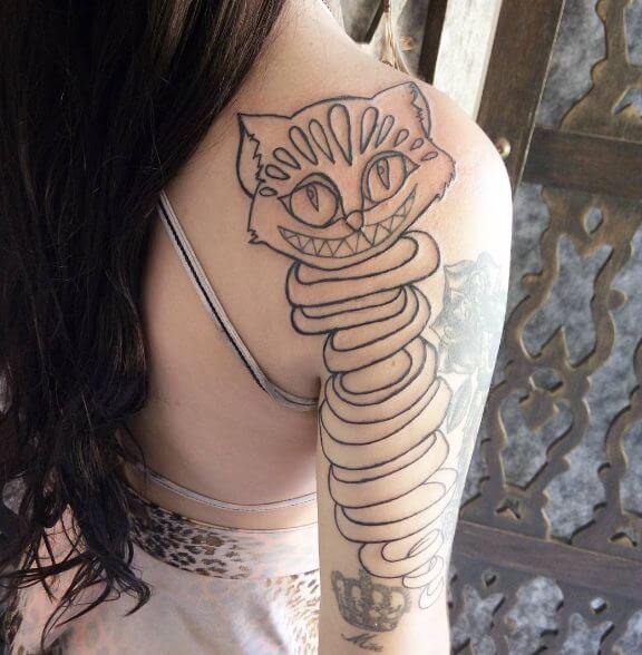 Tatuaje de gato de Cheshire de Alicia en el país de las maravillas en el hombro derecho