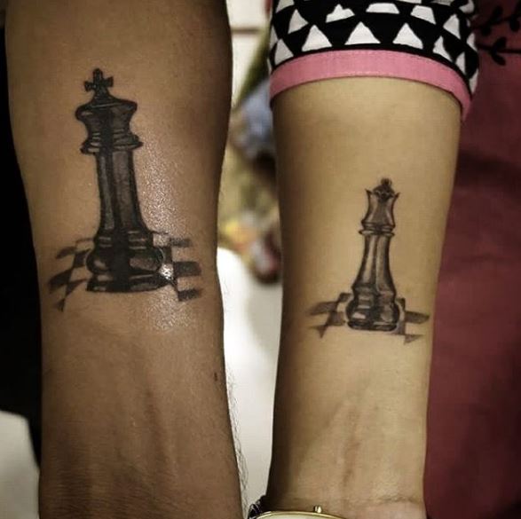 Tablero de ajedrez y diseño de tatuajes de reina en las manos