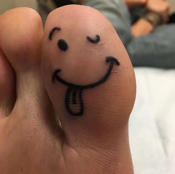 Diseños e ideas divertidos de los tatuajes del dedo del pie de la sonrisa