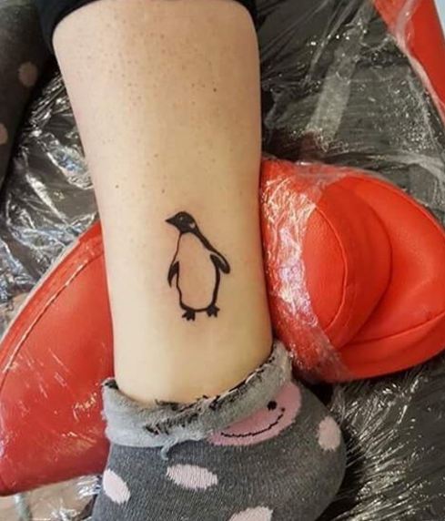 Hermosos tatuajes de pingüinos en la pierna
