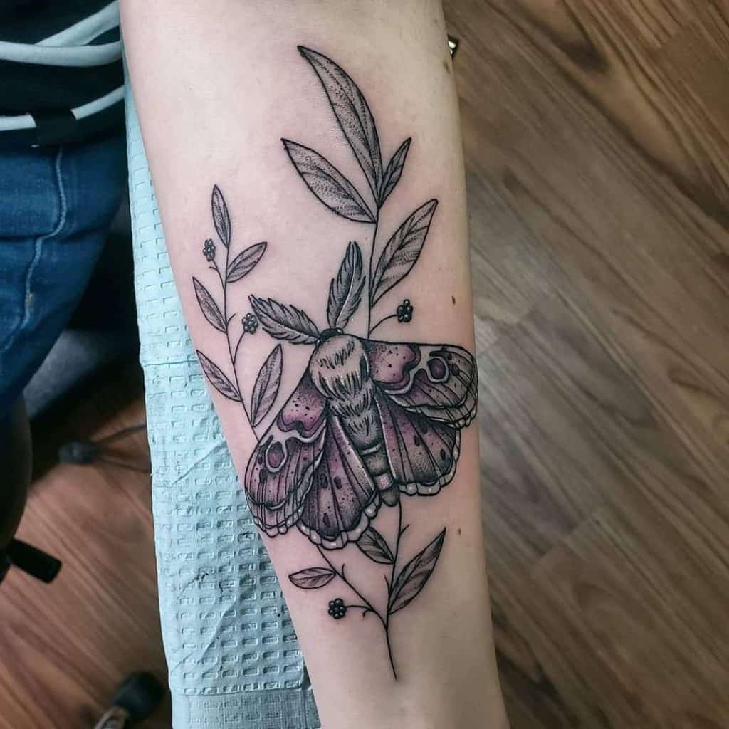 Tatuaje de mariposa y flor en el brazo.
