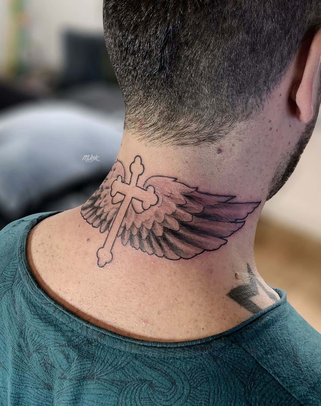 Tatuaje de ala en el cuello