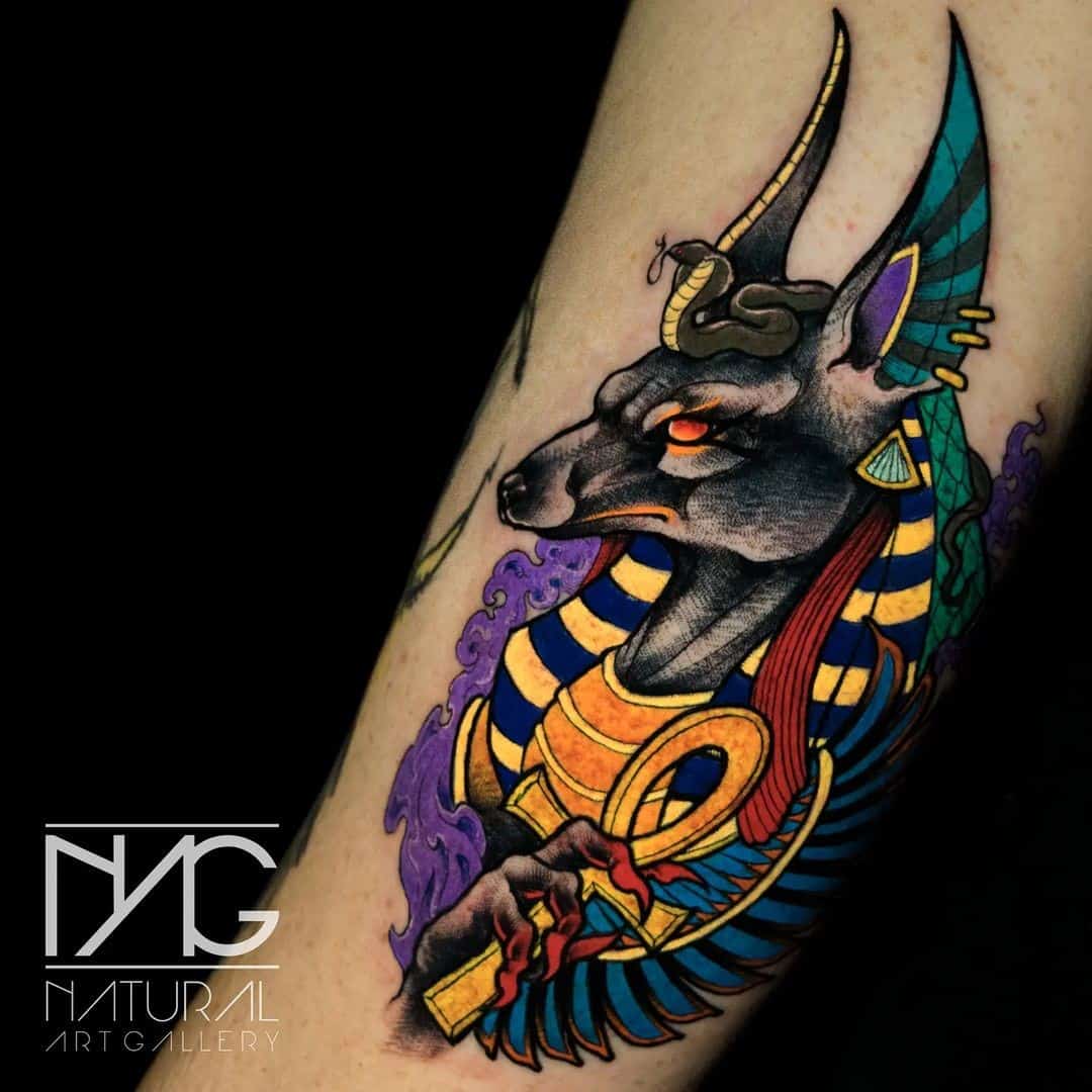 Tatuaje de Anubis en el brazo brillante y colorido