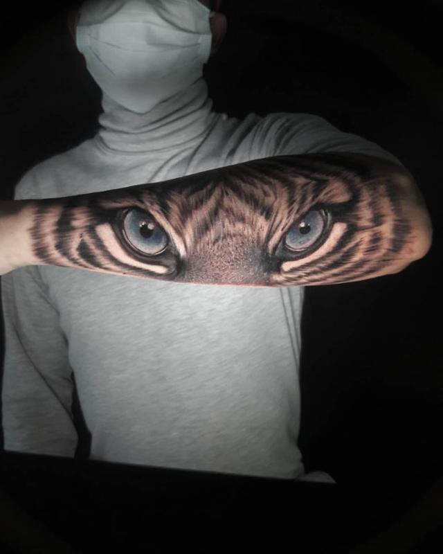 Tatuaje en el brazo, ojo de tigre azul enojado