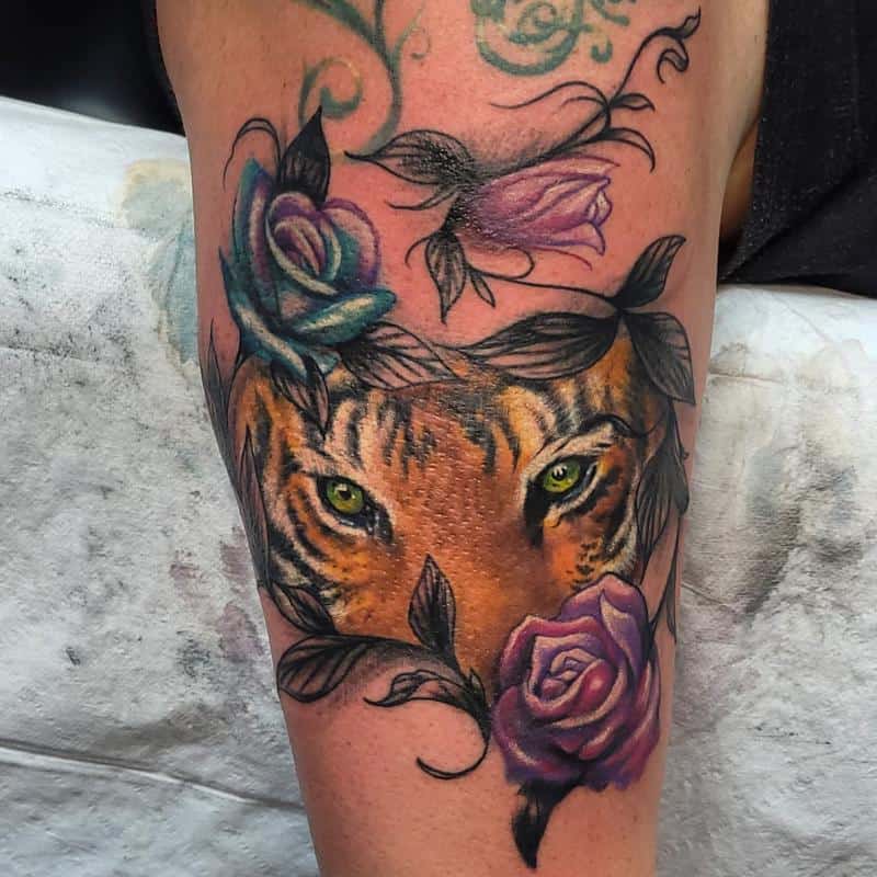 Diseño de tatuaje de ojos de tigre detrás de flores