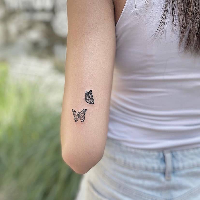 pequeño tatuaje de mariposa en la mano de las mujeres