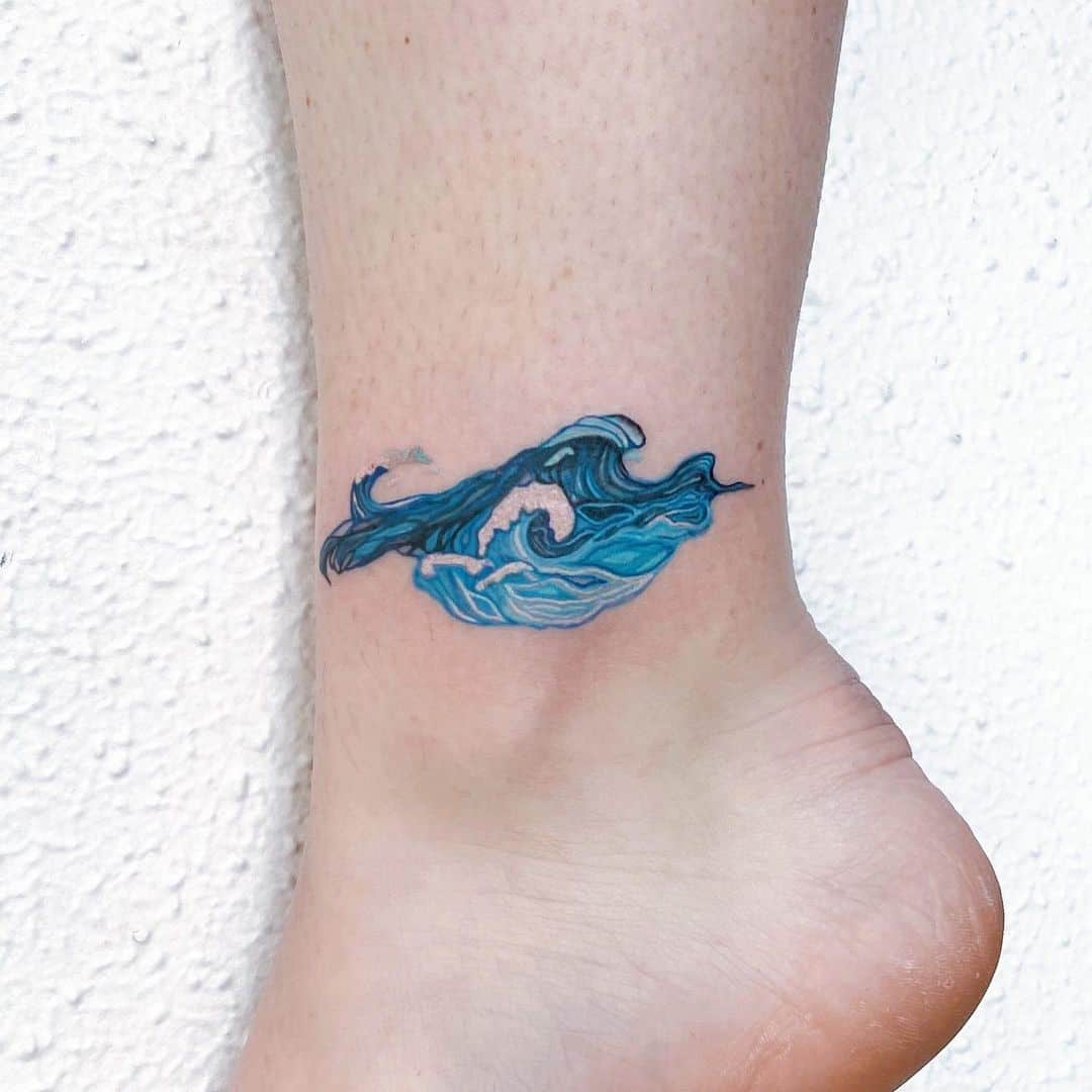tatuajes de olas azules en el pie 