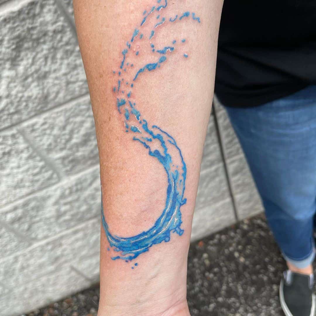 Tatuaje de ola azul en el antebrazo 