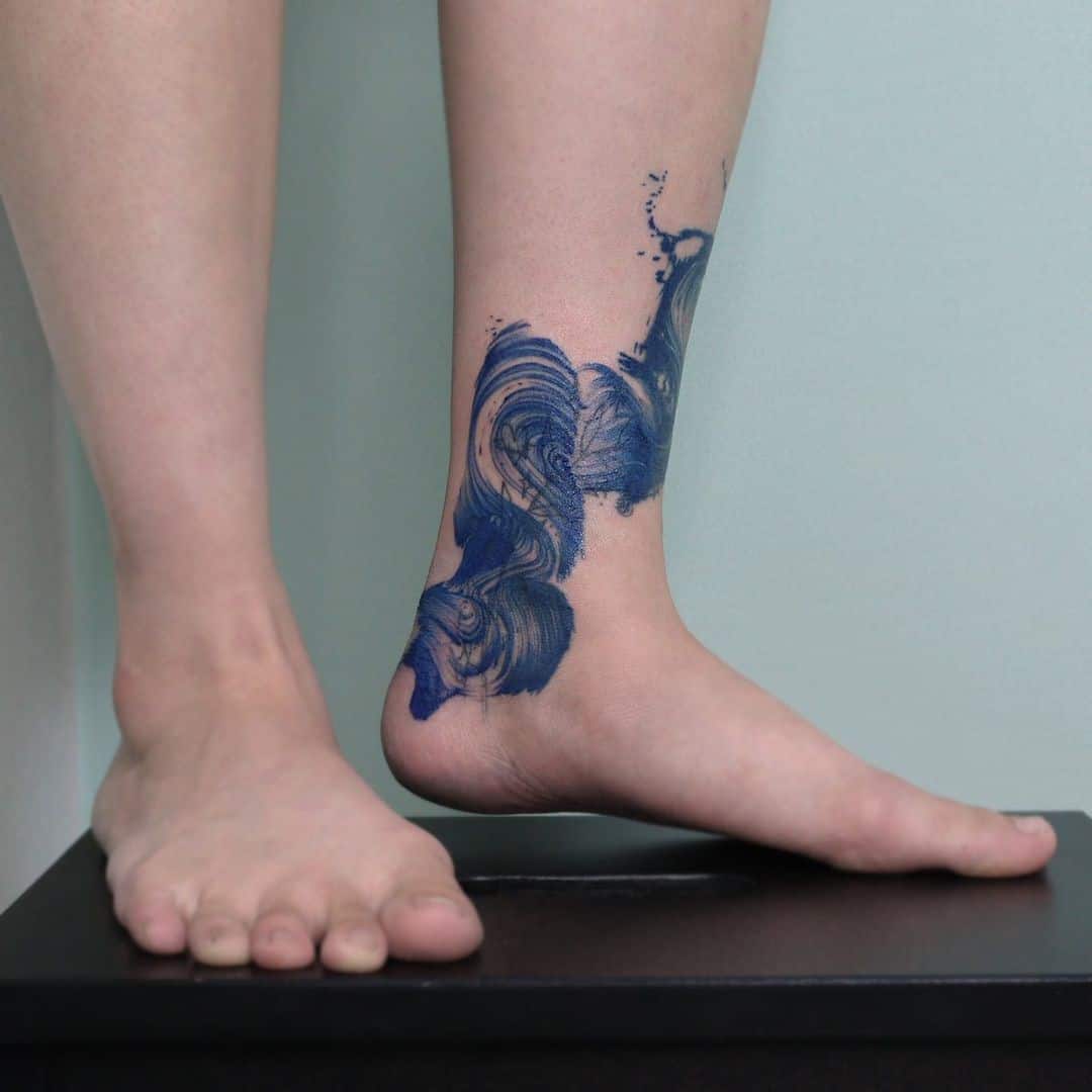 Diseño azul del tatuaje de la onda del pie 