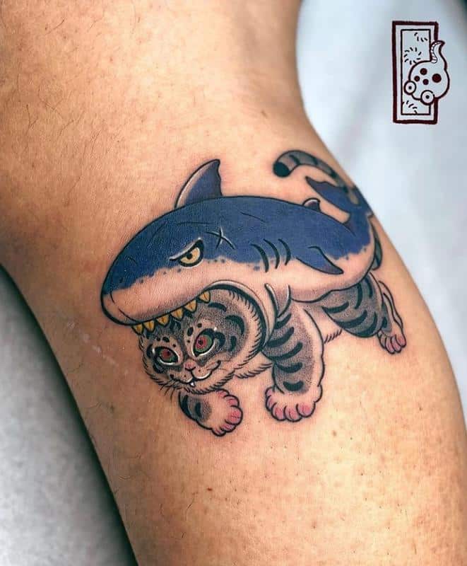 Un gato en un diseño de tatuaje de traje de tiburones