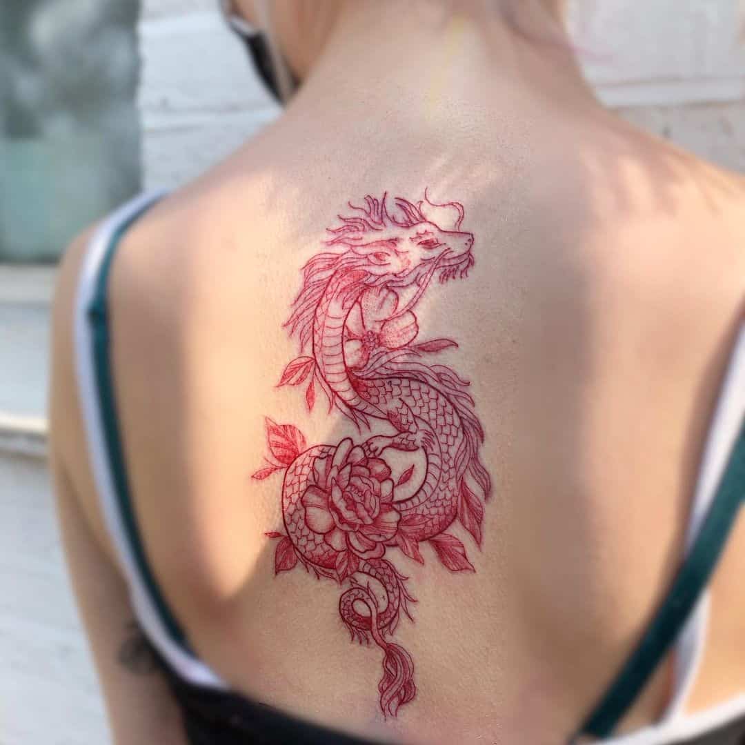 Tatuaje en el brazo, dragón rojo rodeado de flores