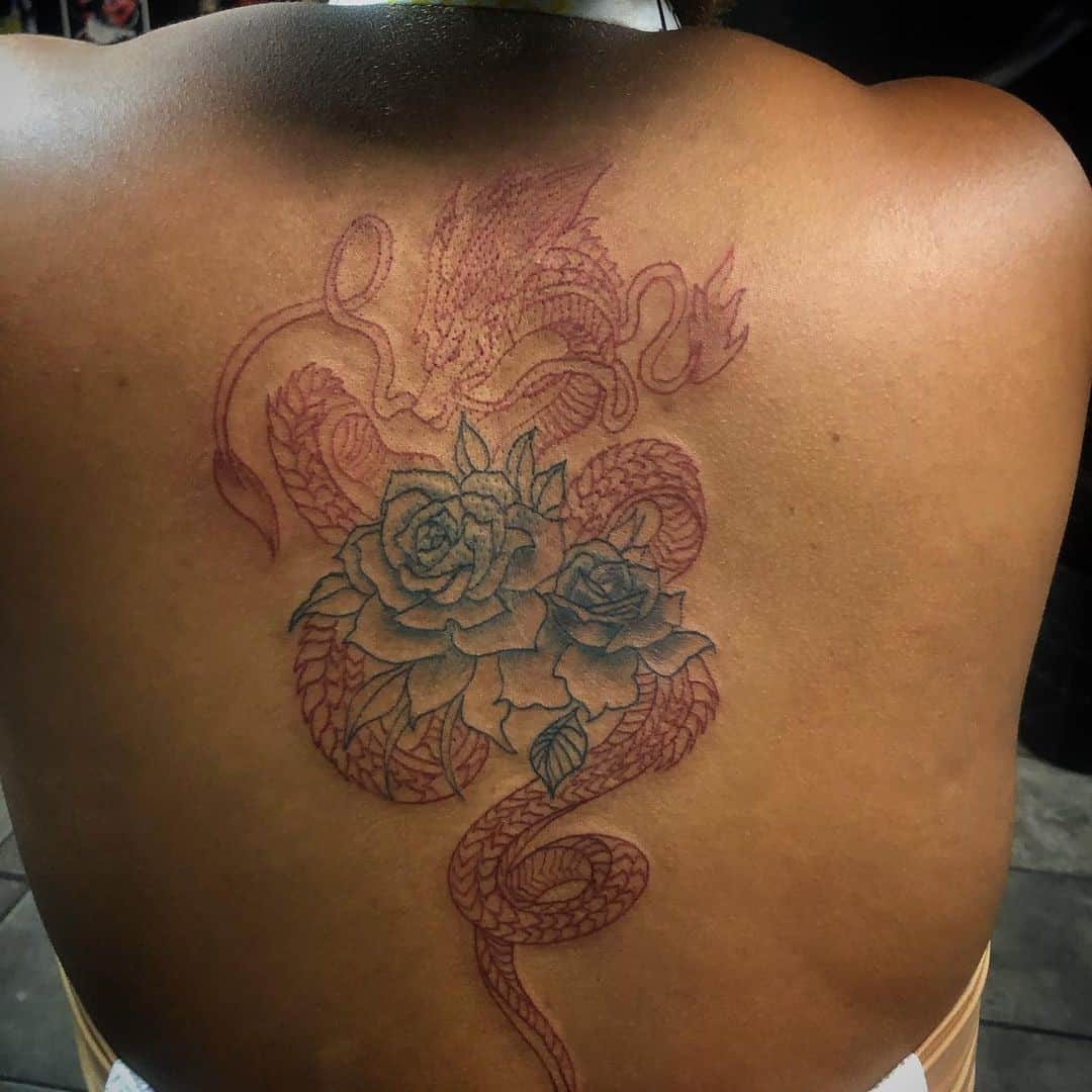 Dragón rojo con diseño de tatuaje de rosas.