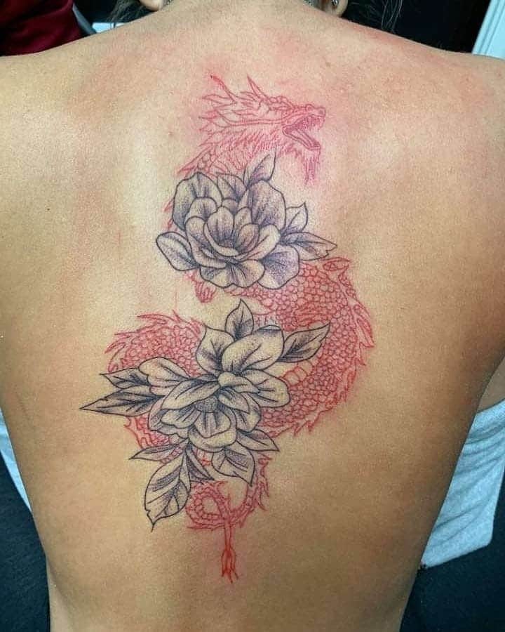 Tatuaje en el brazo, dragón rojo con flores negras