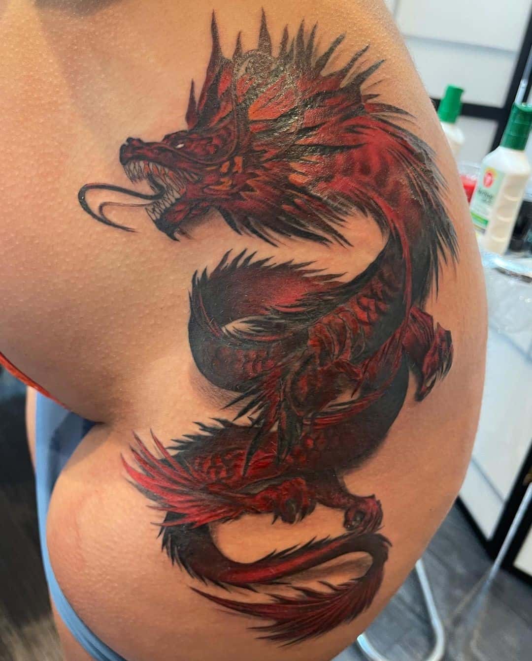 Tatuaje en el brazo, dragón rojo y negro