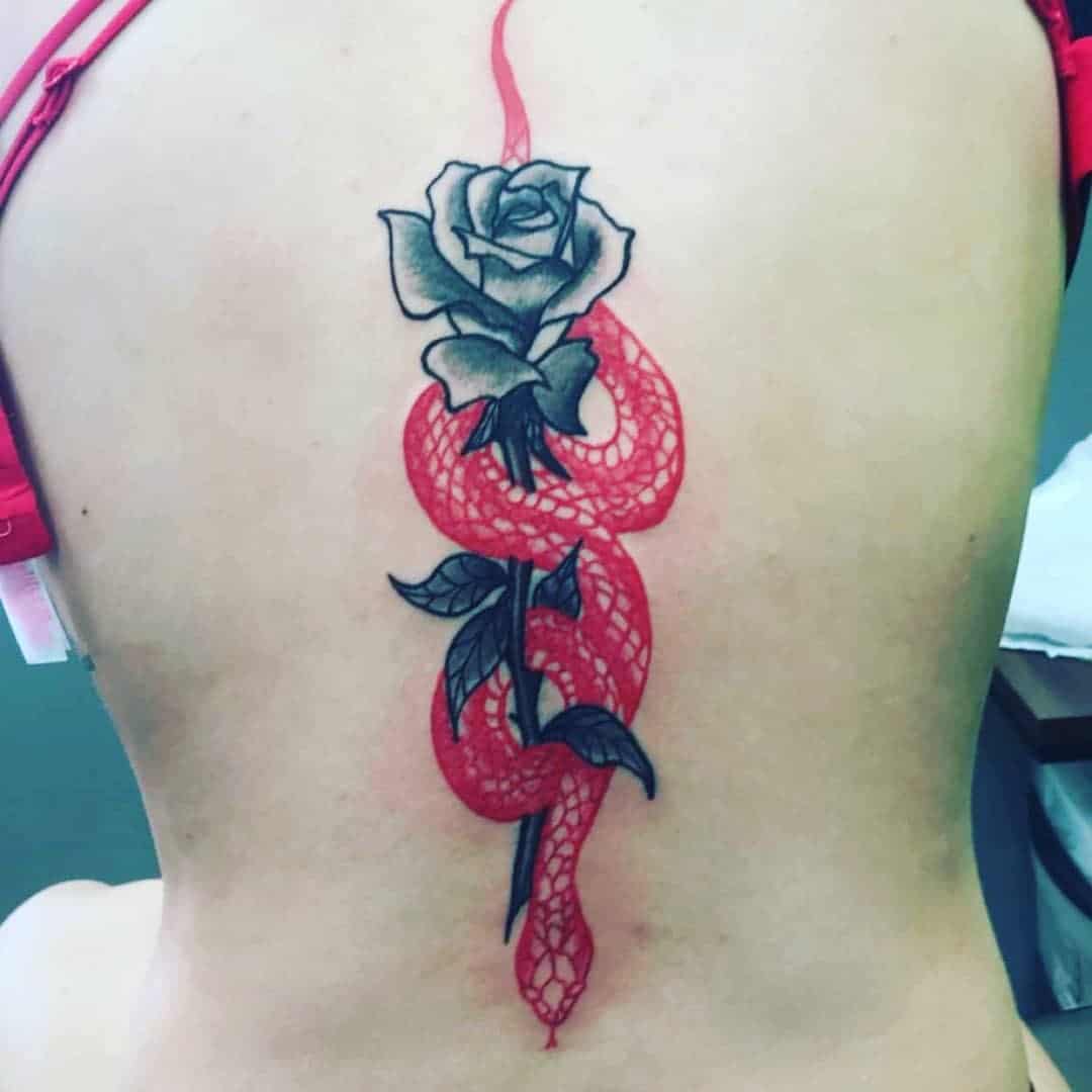 Dragón envuelto alrededor de un diseño de tatuaje de rosa