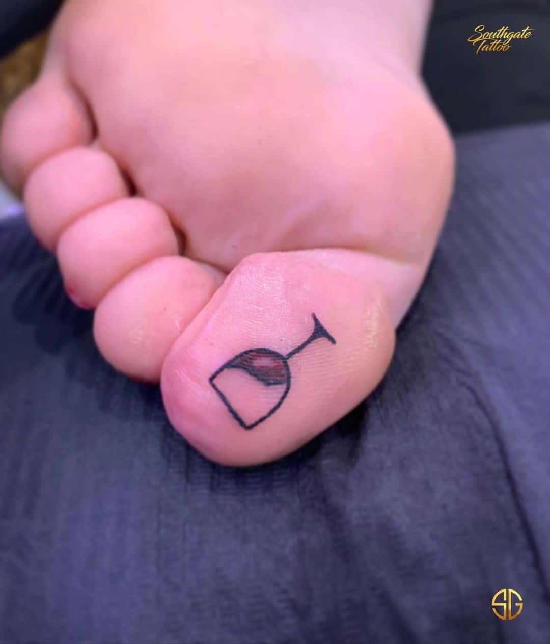 Impresión del tatuaje del dedo del pie del vino 