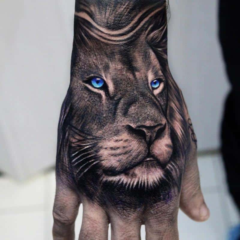 Tatuaje en el brazo, león con ojos azules