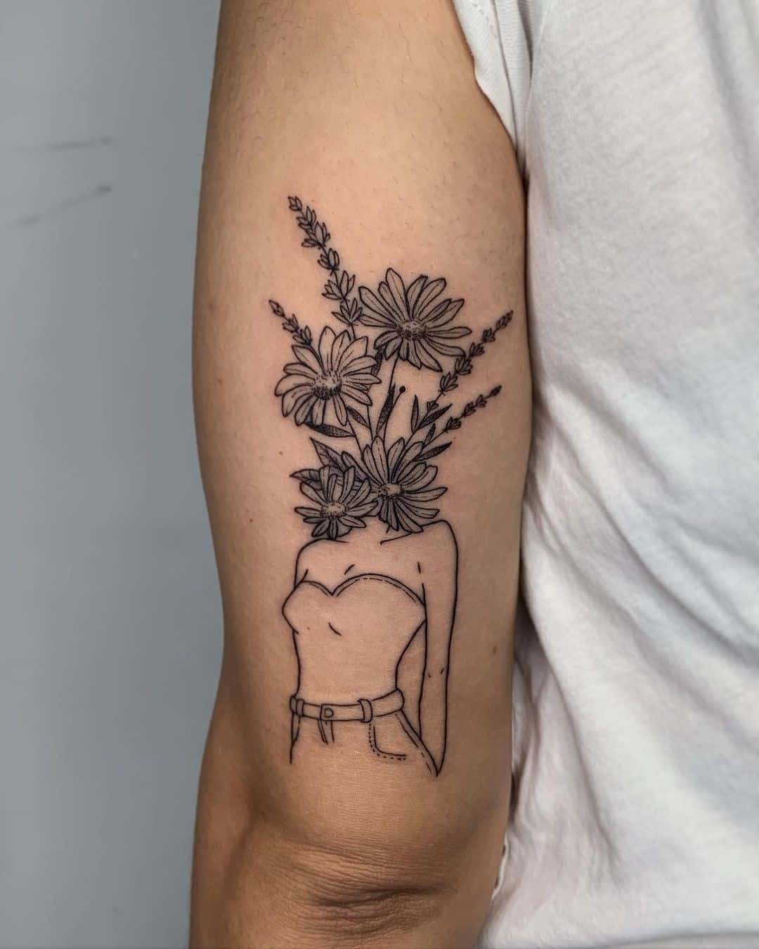 Tatuaje en el antebrazo, flor de aster, tinta negra 