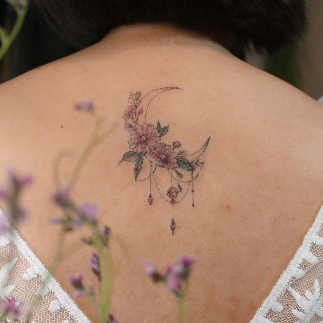 Tatuaje de flor de aster en espalda y cuello 