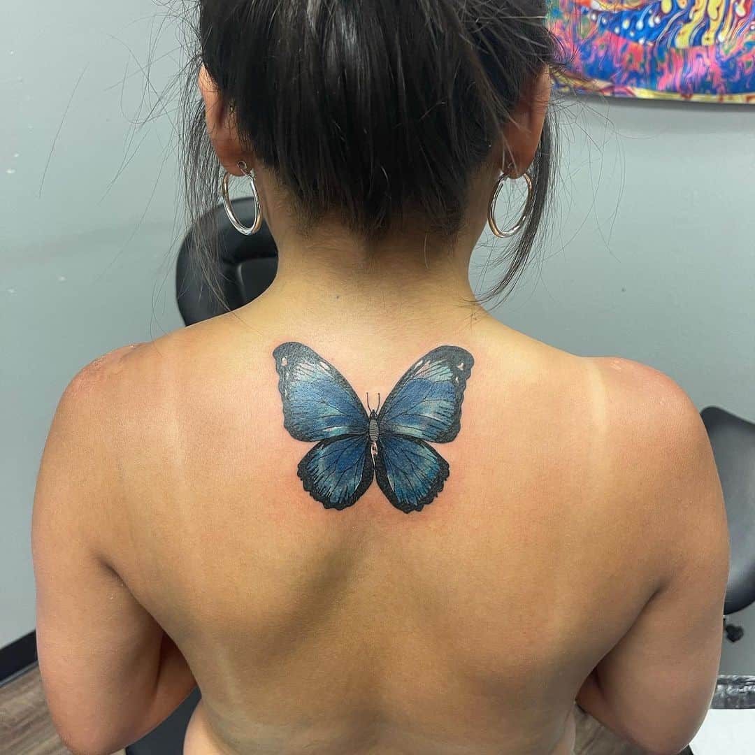 Tatuaje de columna inspirado en mariposa 