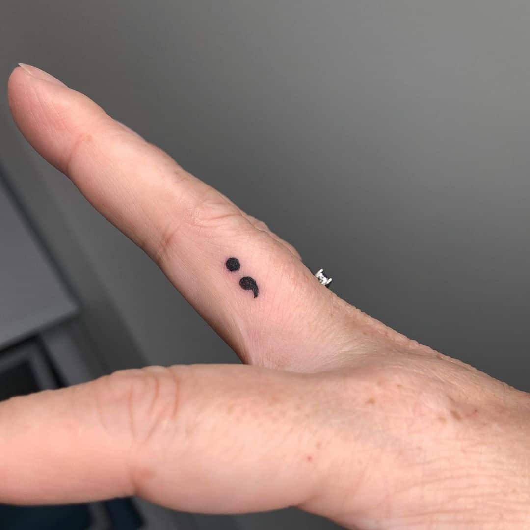 Tatuaje punto y coma en el dedo