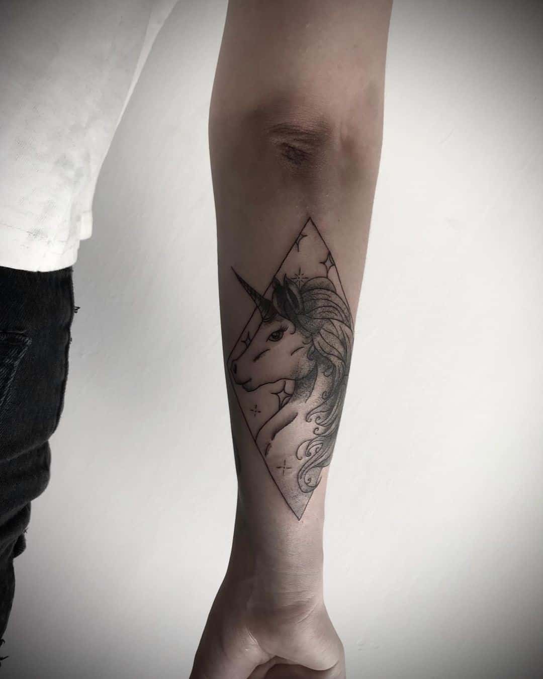 Colocación de brazo de tatuaje de unicornio pequeño