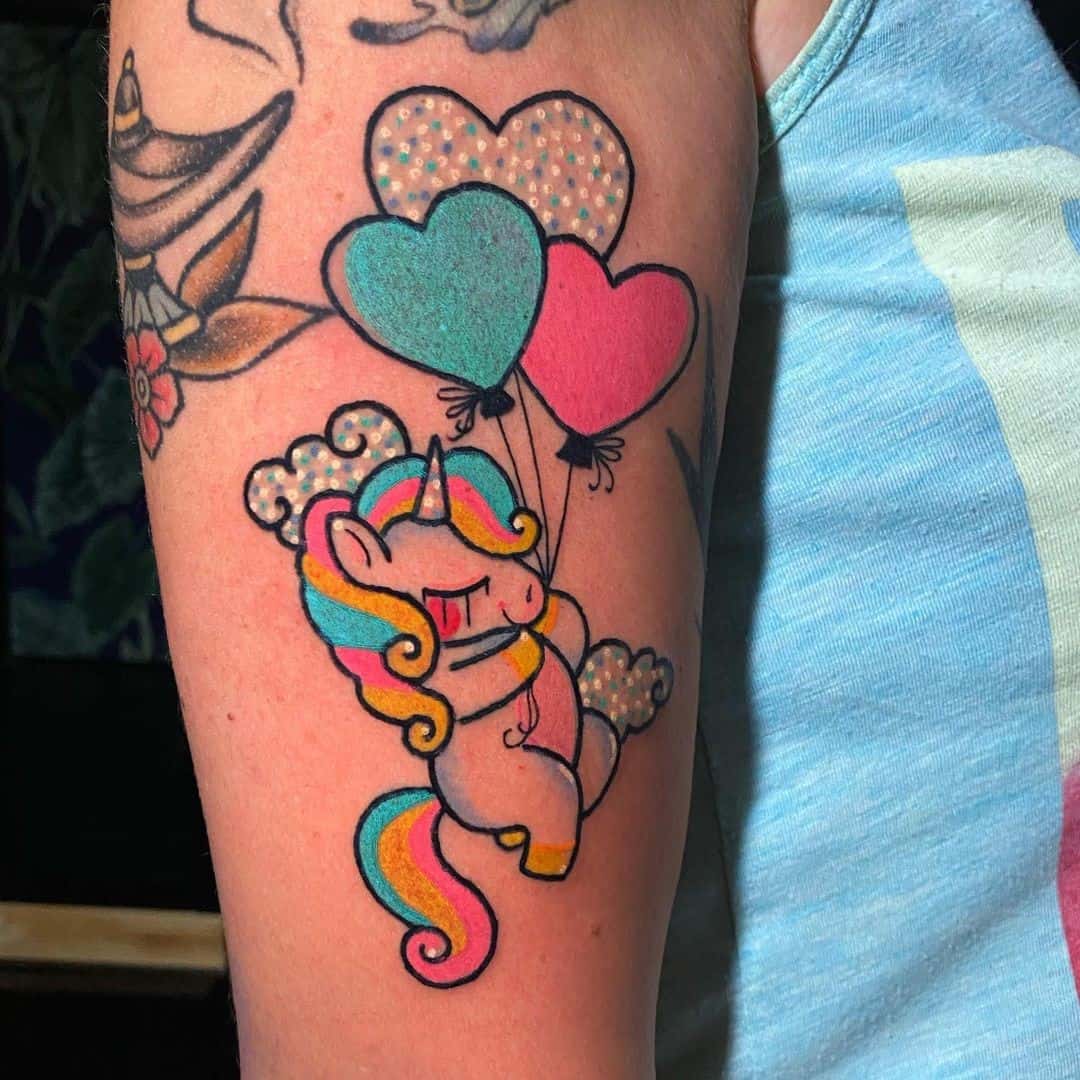 Diseño de tatuaje de unicornio con estampados de corazones 