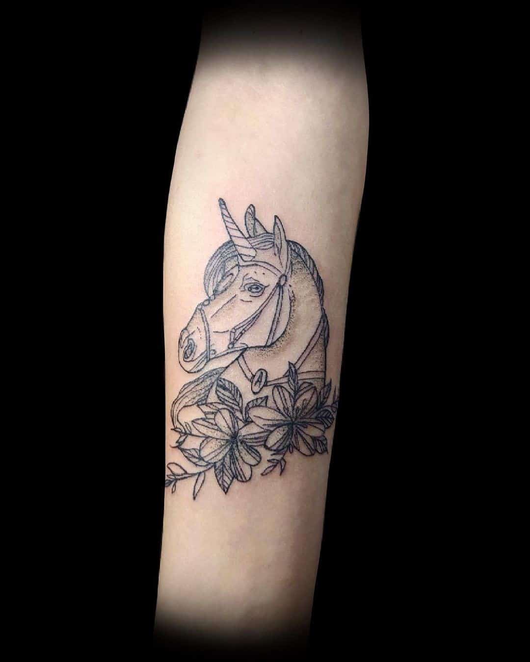 Tatuaje de unicornio oscuro con flores 