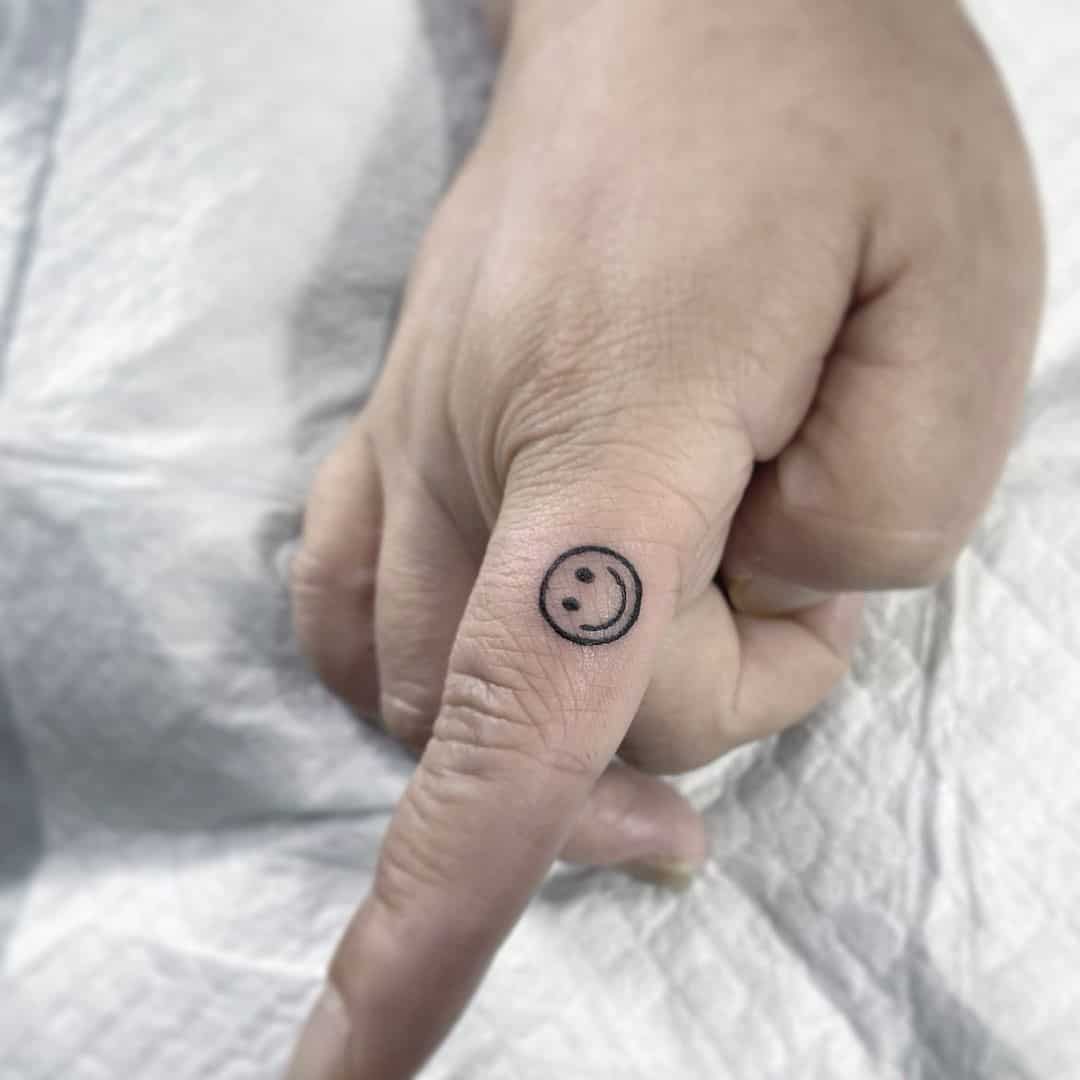 tatuaje de sonrisa en el dedo 