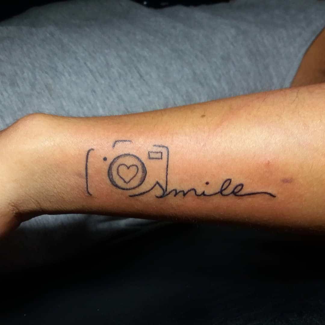 Tinta para brazo de tatuaje de sonrisa optimista 