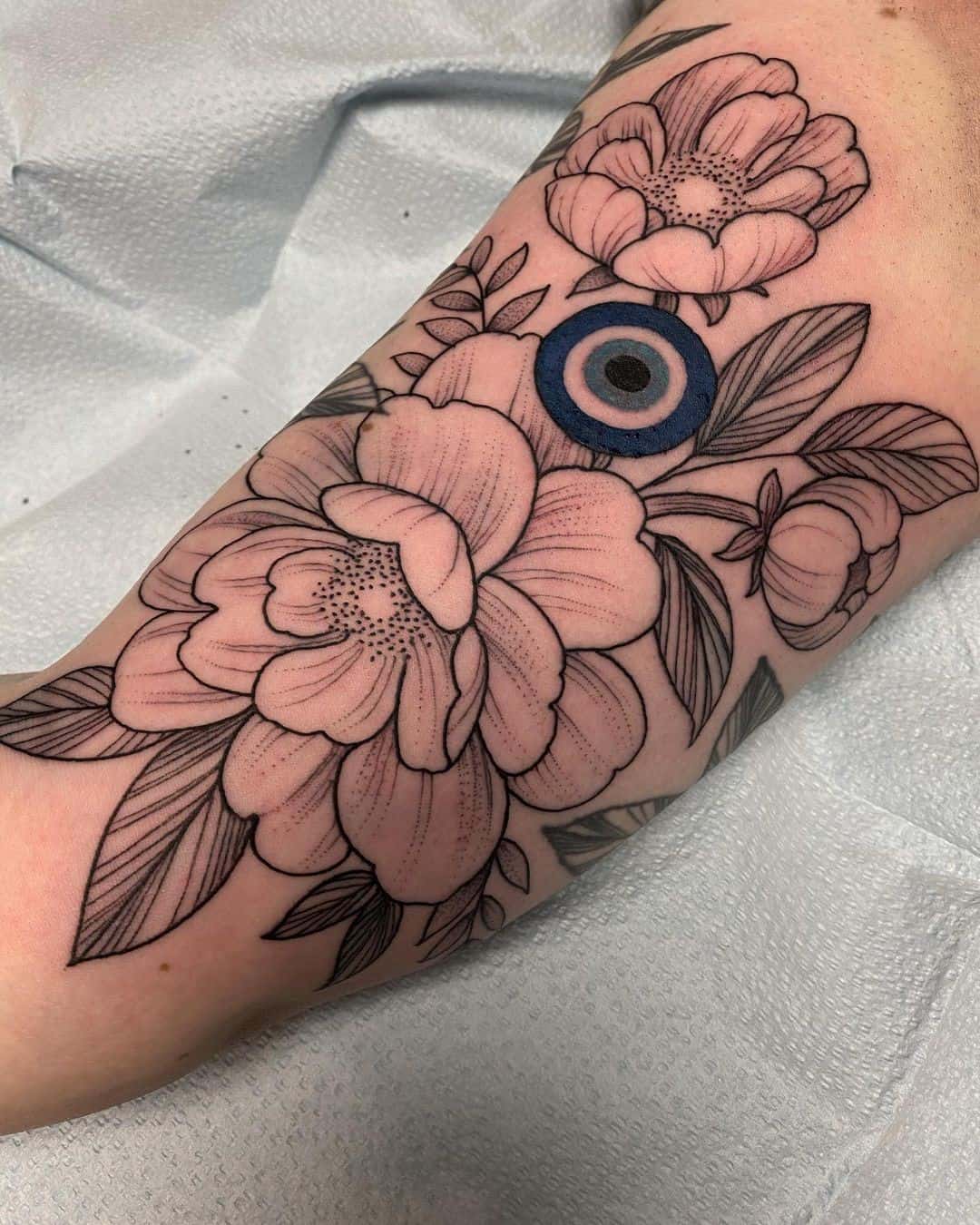 Tatuaje floral y femenino del mal de ojo 