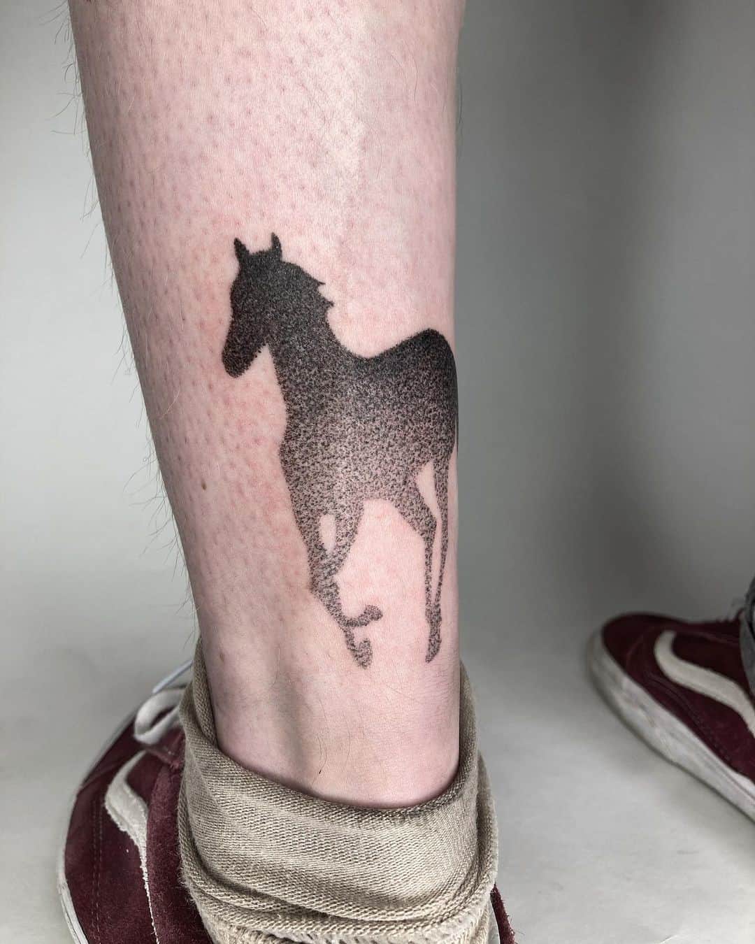 Pequeño tatuaje de caballo en la pierna