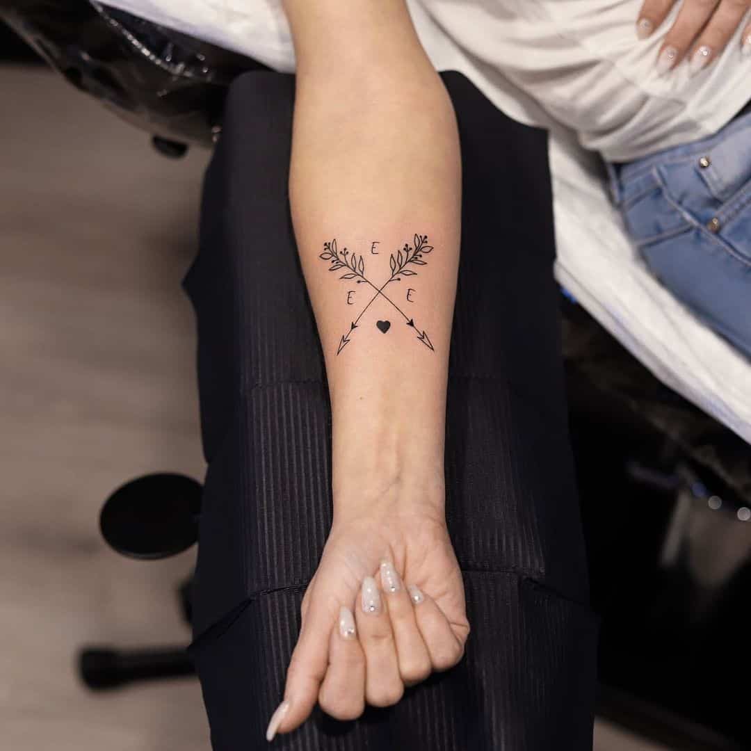Tatuaje de flecha con inicial de nombre 
