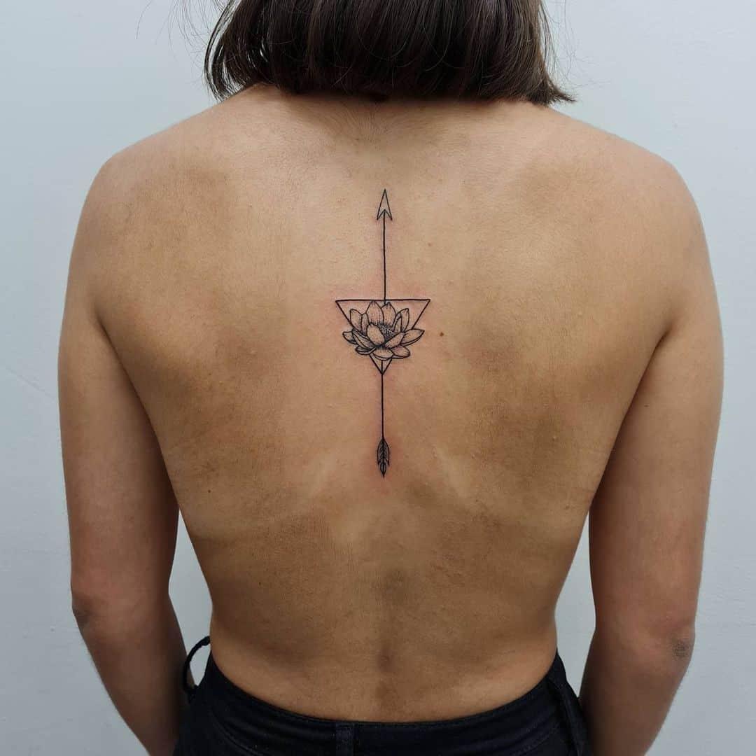 Tatuaje gigante de flecha hacia atrás con idea de flor