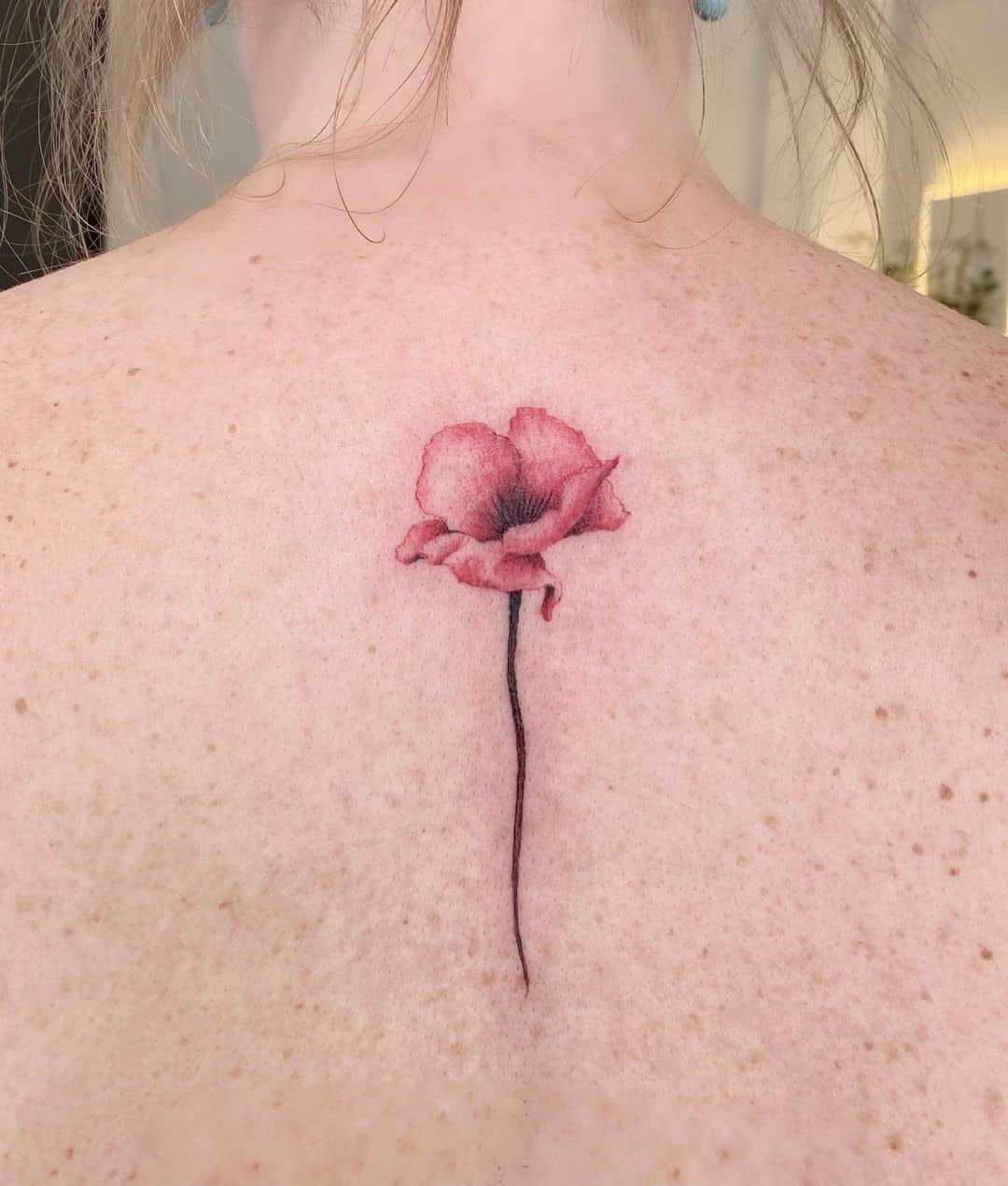 Tatuaje de flor de amapola en el cuello