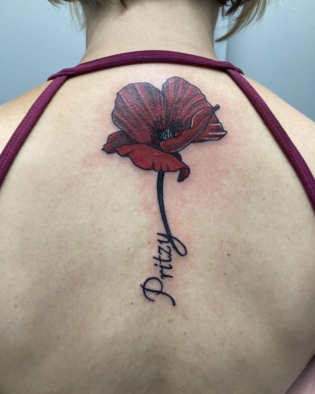 Tatuaje de flor de amapola roja oscura en la espalda